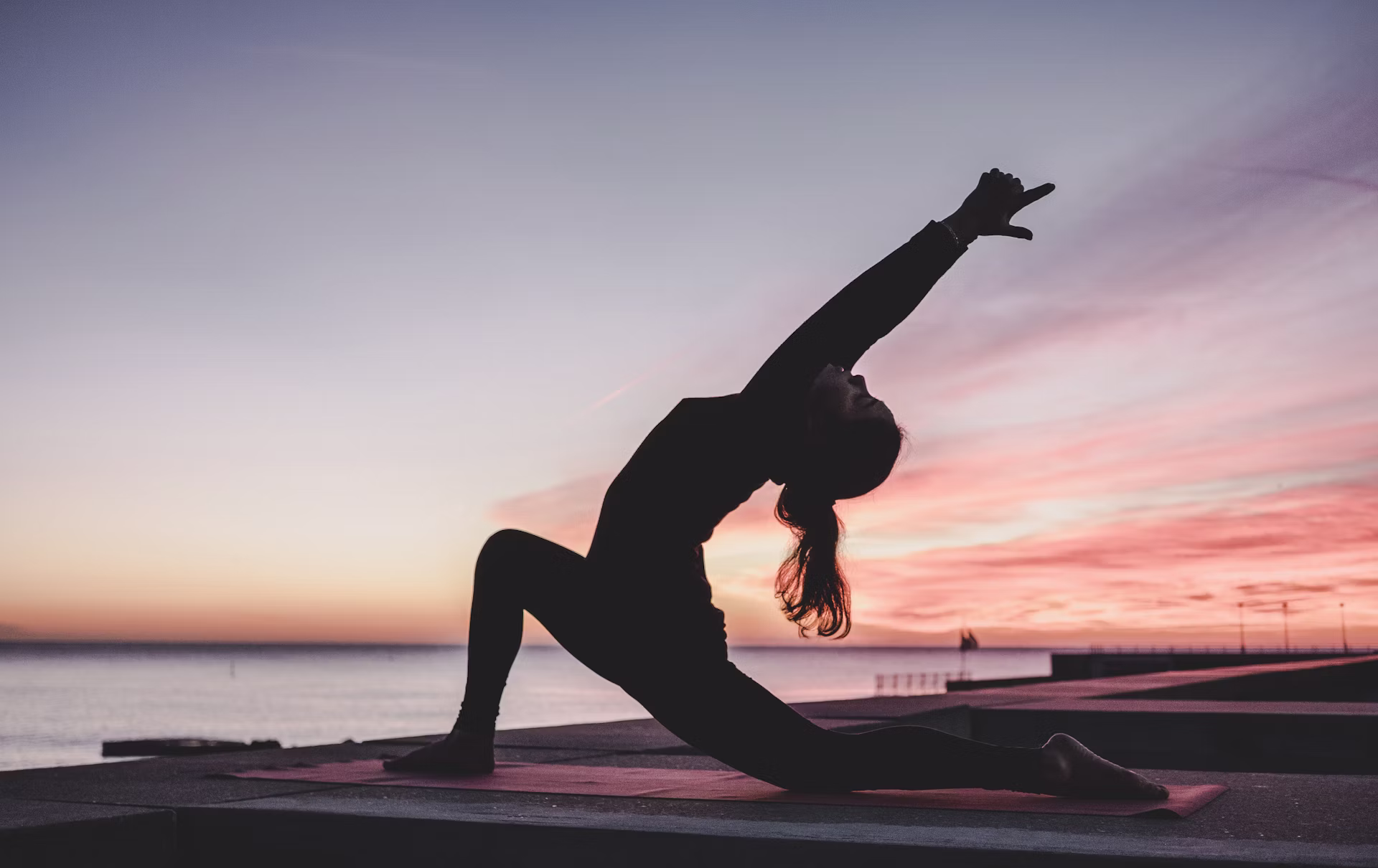 Woman performing yoga pose on mat outdoor